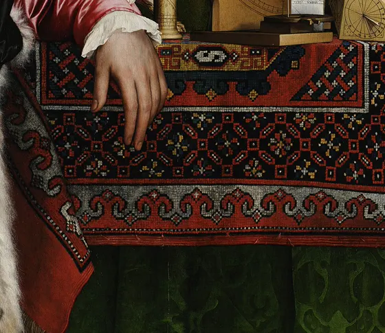 A hand resting on a patterned carpet